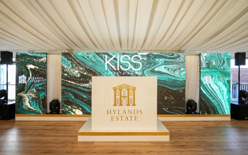 A DJ booth with a gold Hylands Estate logo.
