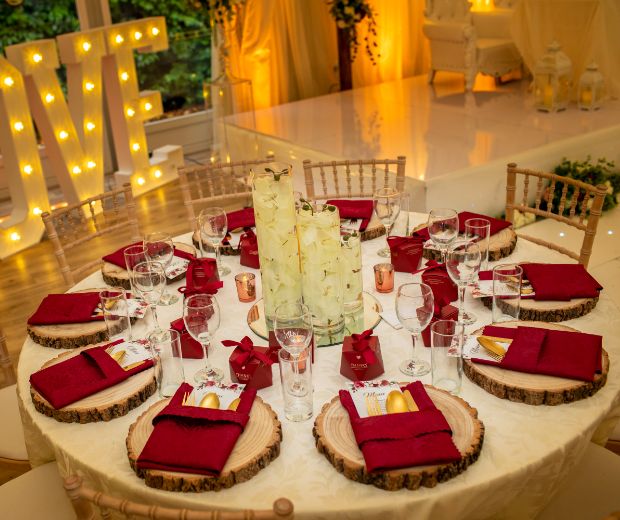 A table setting with red napkins and natural wood placemats. 
