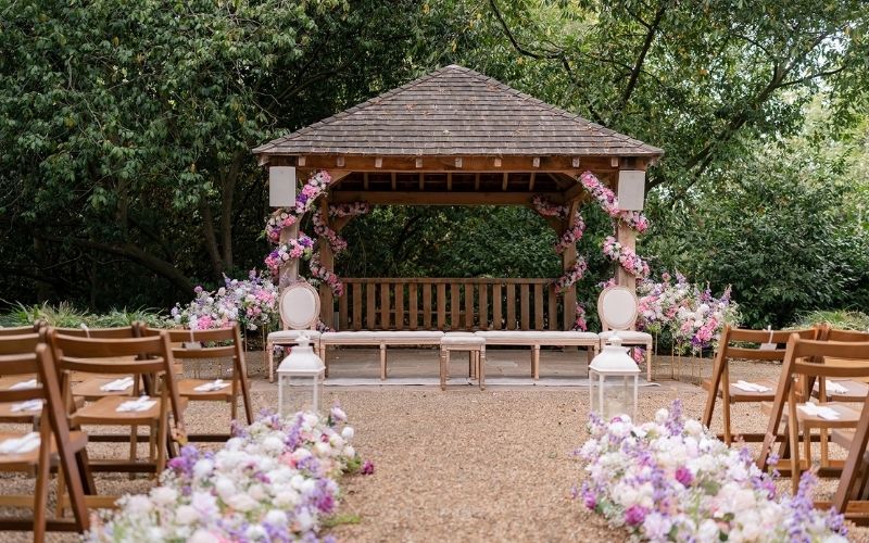 The Outdoor Ceremony Garden with purple and pink floral decorations.