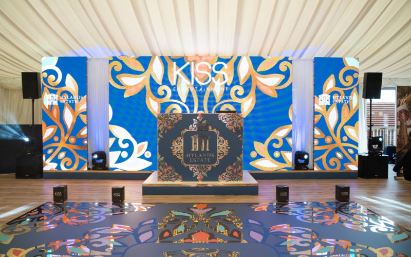 A dance floor and DJ booth decorated with blue and gold designs.