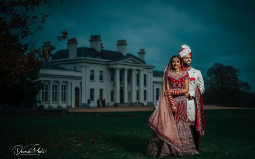 A couple posing outside Hylands House at dusk.