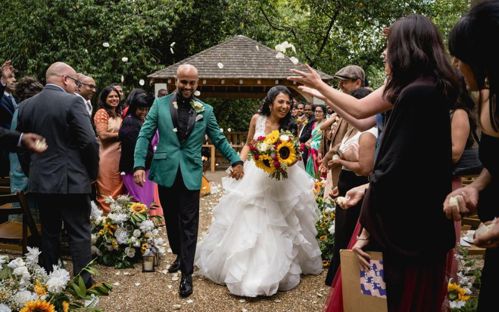 Ratha and Rath walking down the aisle of the outdoor ceremony garden