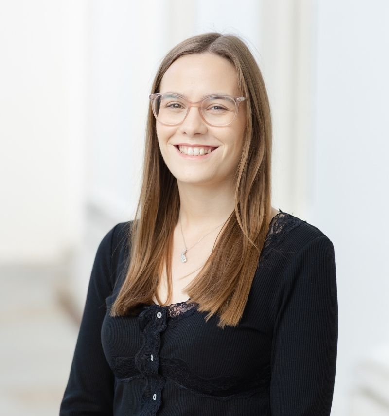 Charlotte, a woman with long brunette hair and glasses. 