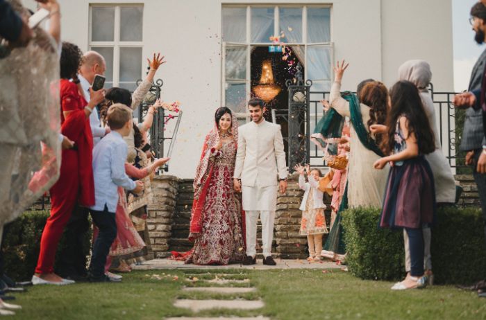 Family and friends throwing confetti on a bride and groom. 