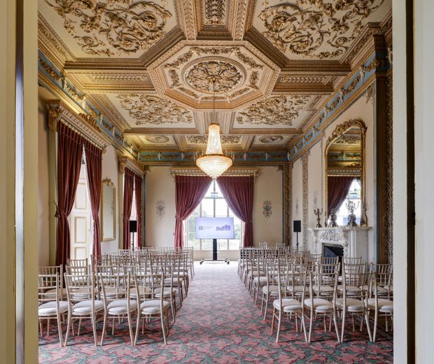 The Drawing Room set with chairs in a theatre style. Two musicians are playing at the front of the room.